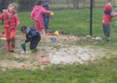 Eleves jouant sous la pluie dans une cour de recreation