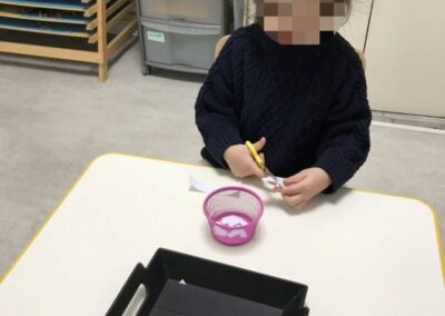 eleve decoupant des fiches lors d'un atelier Montessori
