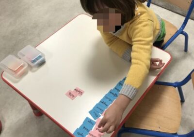 Eleve apprenant a associer des mots a l'aide de fiches